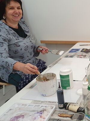 Teilnehmerin mit Spachtel und Pinsel